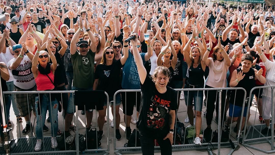 Publikum s rukami nad hlavou počas letného koncertu TEAM Revival Martin